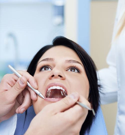 Dentist is examining female patient teeth